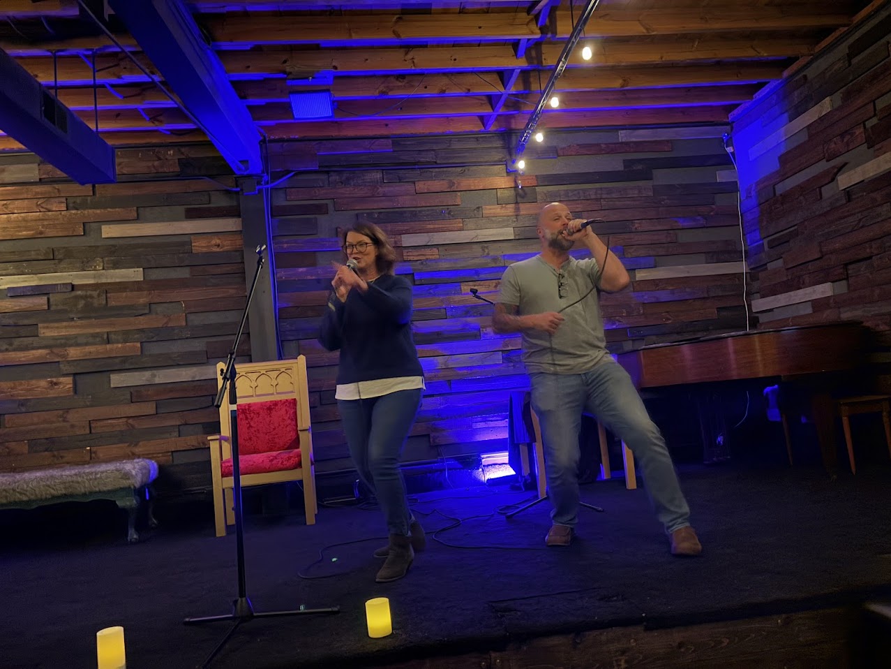 two people singing karaoke on stage at Foundry